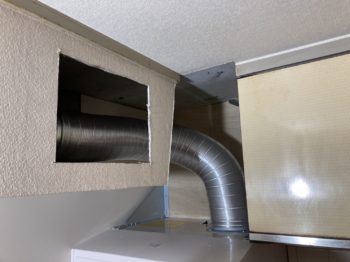 梁と吊り戸に囲まれたレンジフードの交換現場に密着